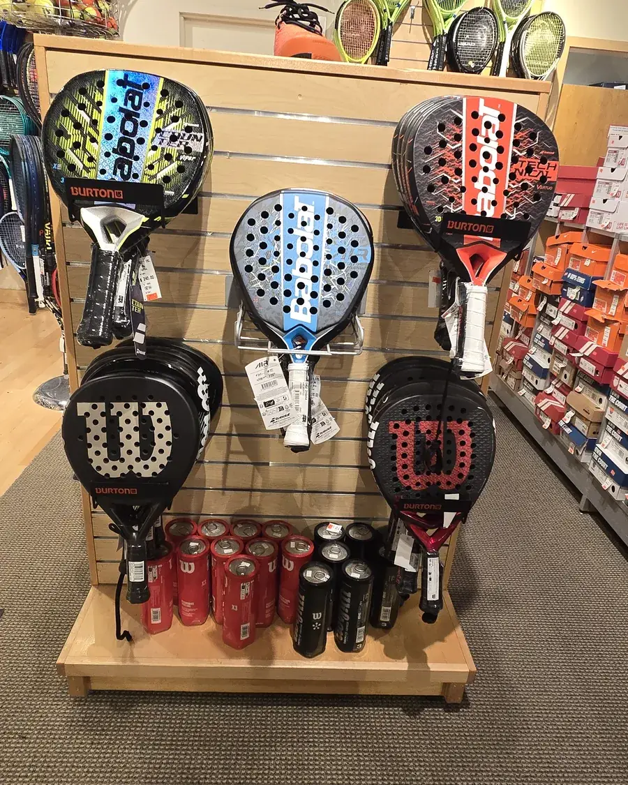 The padel endcap at the Mequon shop with Babolat and Wilson rackets.