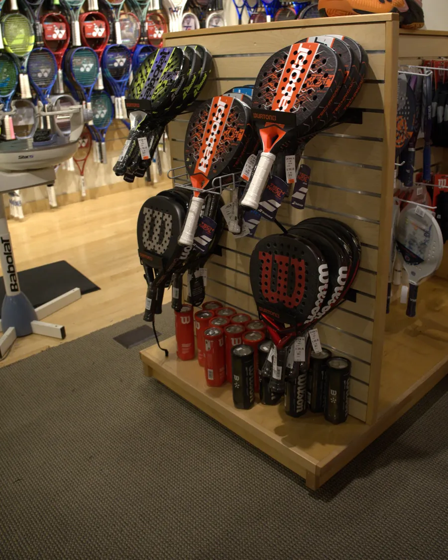Babolat and Wilson padel rackets on the rack at the Mequon shop.