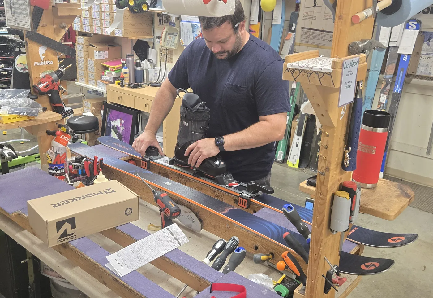A technician mounting bindings at the workbench in the Mequon shop.
