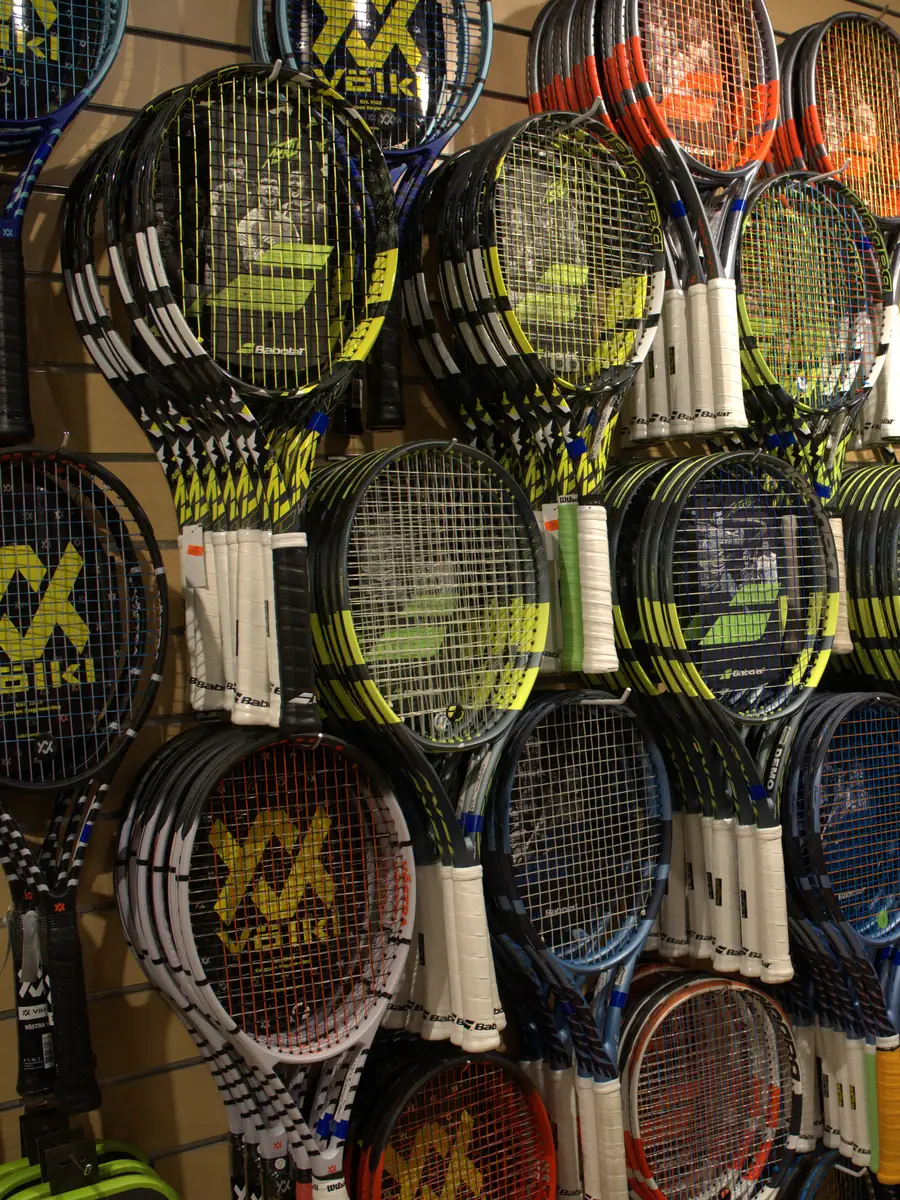 Babolat and Völkl racquets on the wall at the Mequon shop.